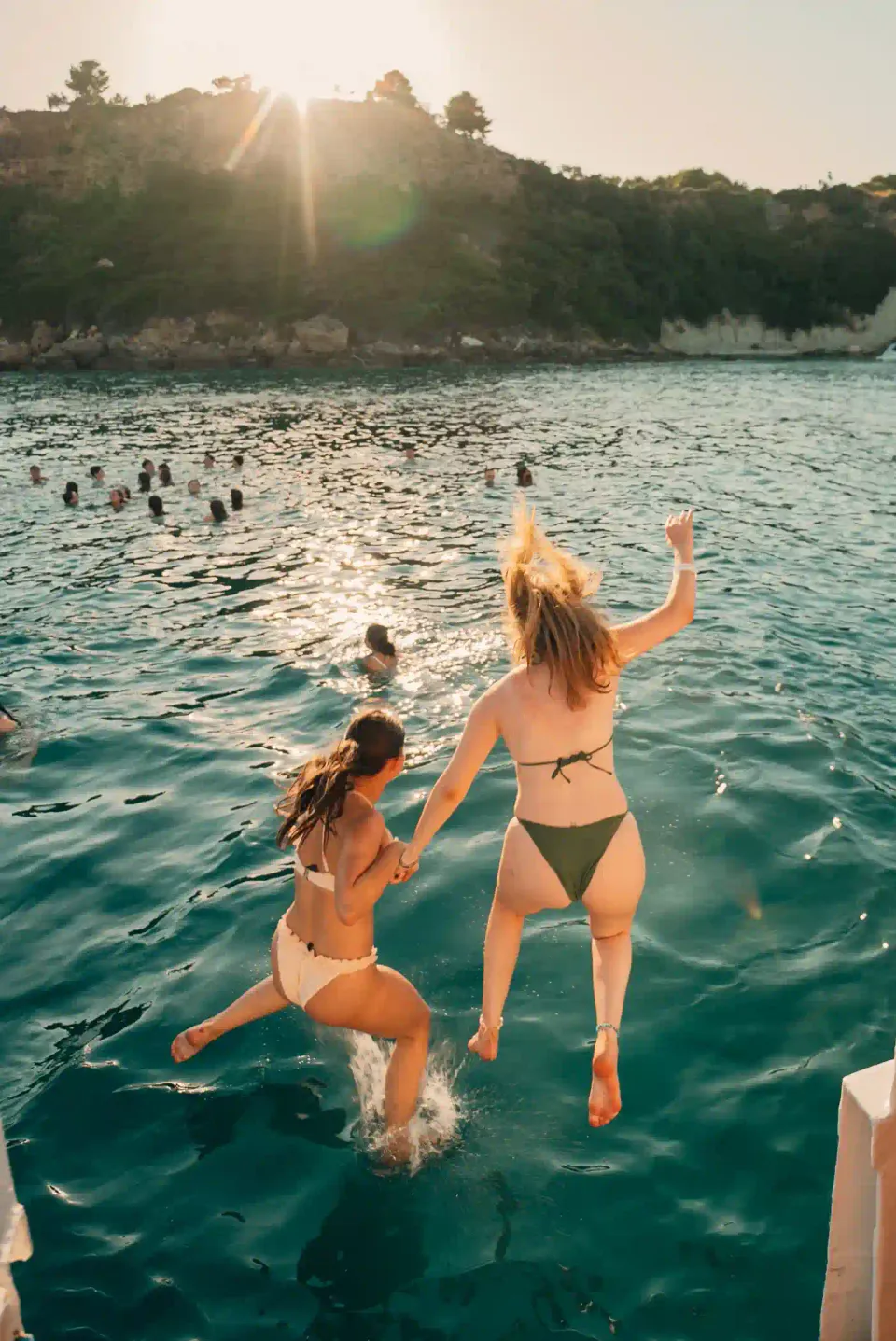Two guests jumping into the sea during the yacht swim stop
