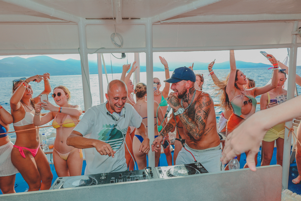 DJs performing while guests dance beneath the yacht canopy